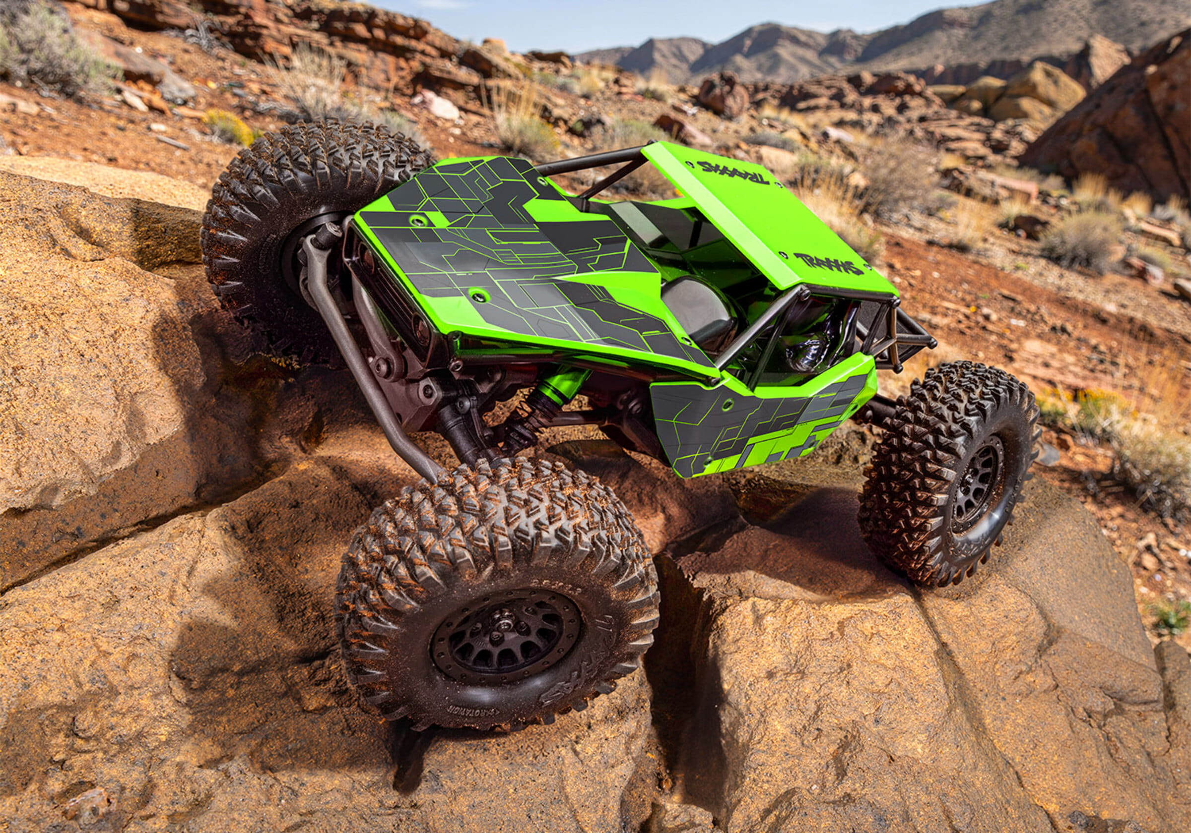 Grüner Traxxas TXC-4M Extreme Crawler mit 4x4-Antrieb beim Klettern über große Felsen im Gelände